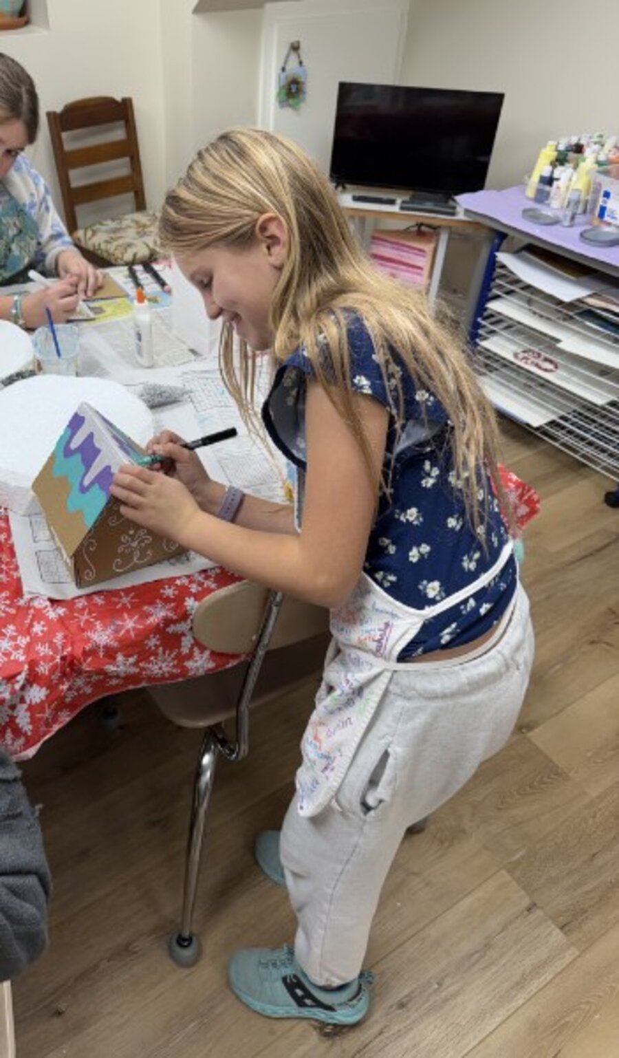 Camper decorating a sculpted house project with a paint pen